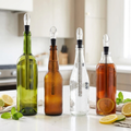 Four bottles — wine, kombucha, sparkling water and iced tea — each fitted with a Chill Wand